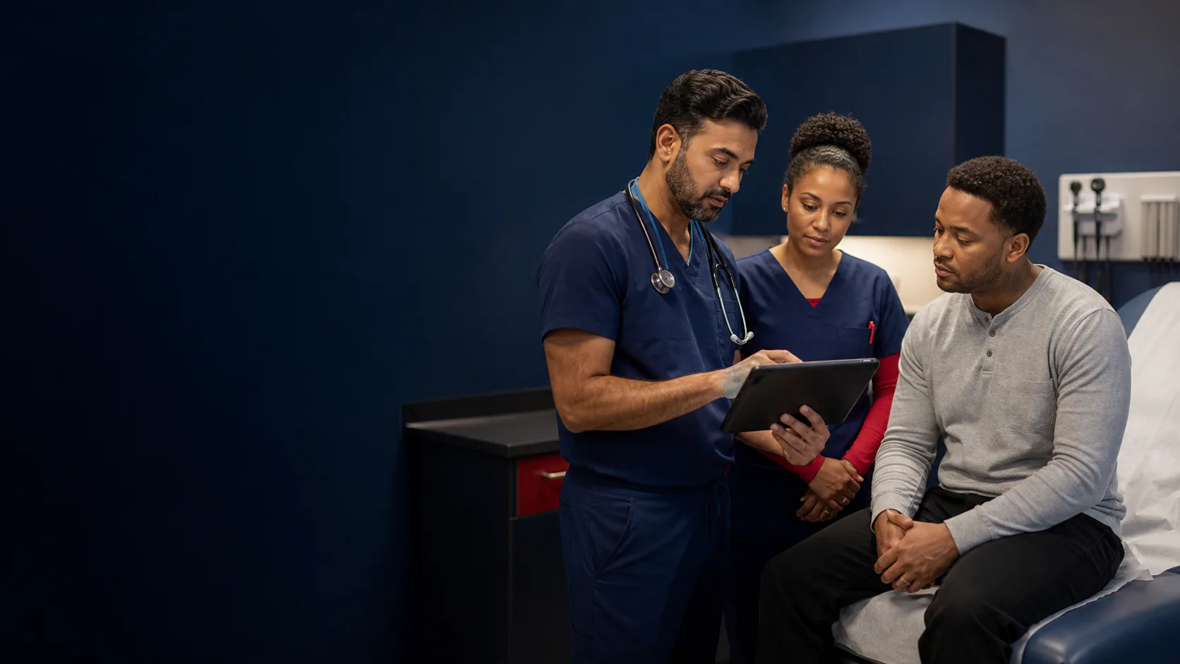 Emergency physician and nurse reviewing diagnostic information with a patient